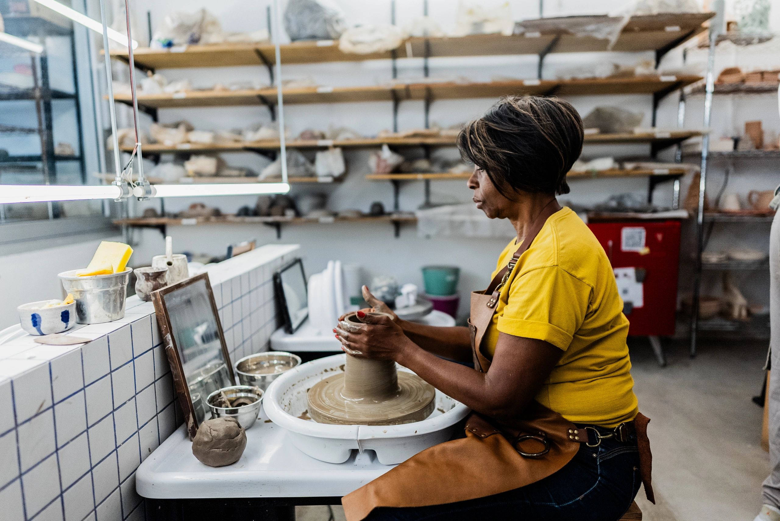 Artist shaping clay on a pottery wheel
